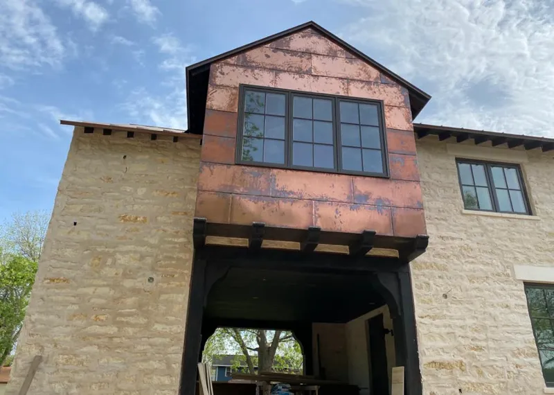 Copper metal panel facade on a stone building for Skylight Installation in Waupun